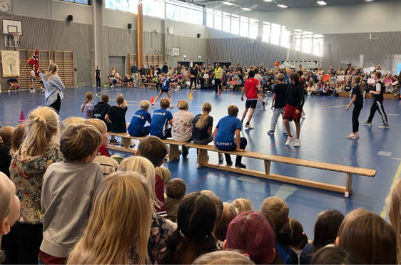 Elever som ser på dodgeball-finale i gymsalen