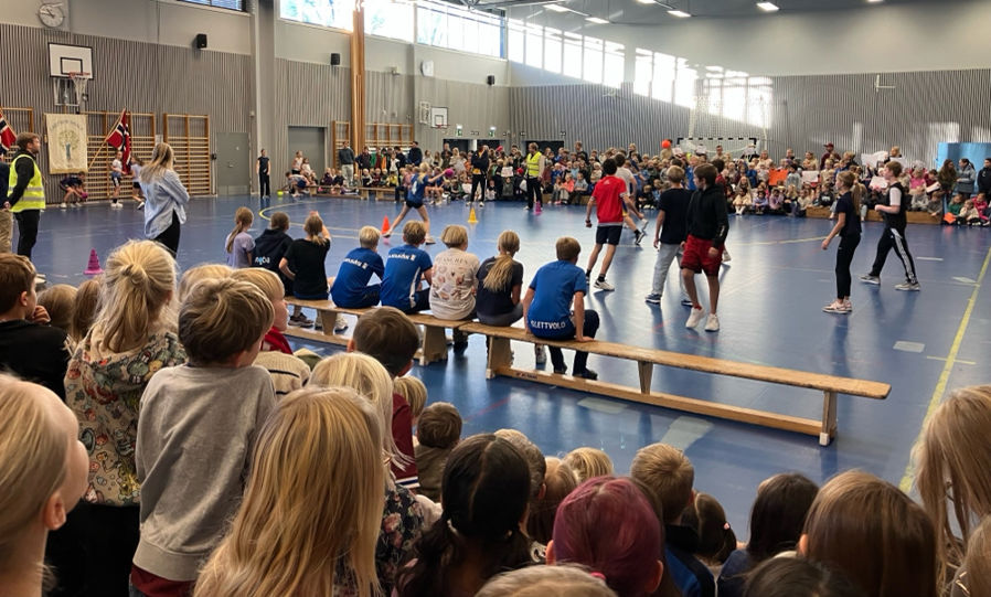 Elever som ser på dodgeball-finale i gymsalen